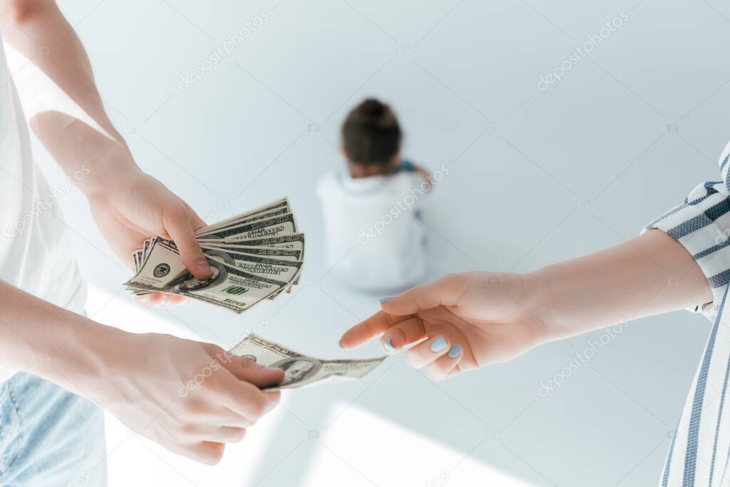 selective focus of man giving alimony to woman near daughter on white
