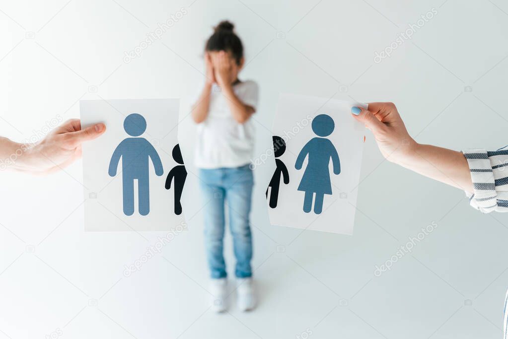 selective focus of man and woman holding ripped paper with separated family near adopted african american daughter on white 