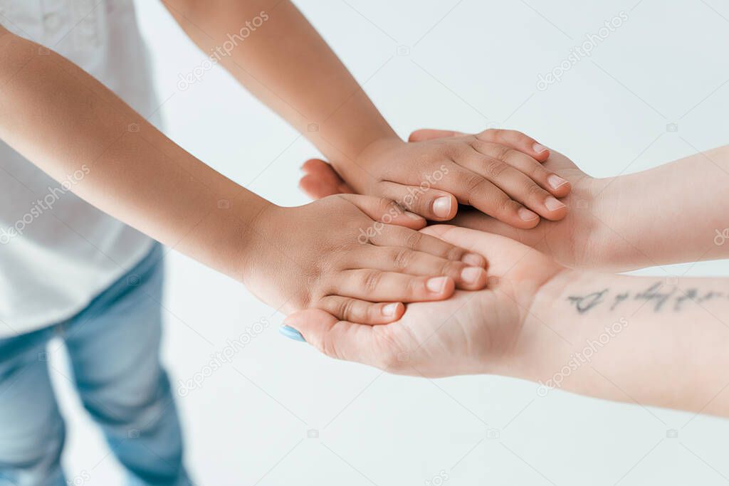 cropped view of foster mother holding hands with adopted african american kid isolated on white 
