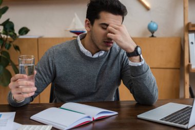 Ofiste migrenden muzdarip bir iş adamı.