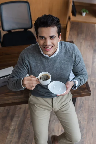 Vista Alto Ângulo Empresário Com Pires Xícara Café Sorrindo Olhando — Fotografia de Stock