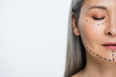 Griye izole edilmiş plastik cerrahi çizgileri olan Asyalı bir kadının yüzünün yarısı. 