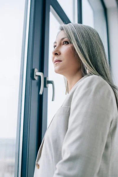 Thoughtful Asian Businesswoman Grey Hair Grey Suit Looking Window — Stock Photo, Image
