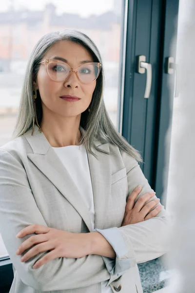 Confident Asian Businesswoman Crossed Arms Grey Suit Eyeglasses Office — Stock Photo, Image