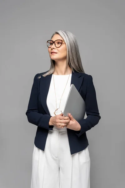 Confident Asian Businesswoman Grey Hair Holding Laptop Isolated Grey — Stock Photo, Image