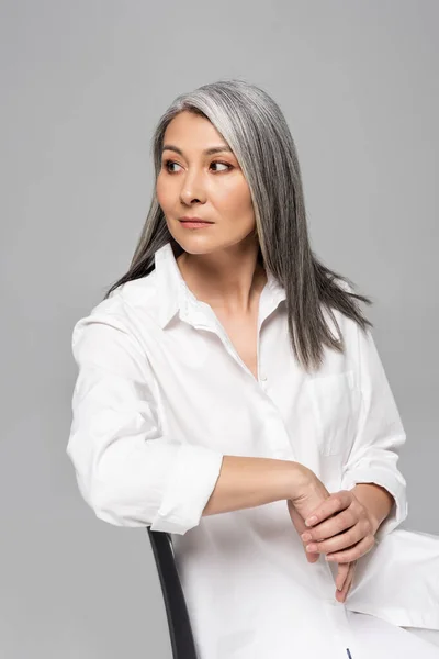 Confident Asian Woman Grey Hair Sitting Chair Isolated Grey — Stock Photo, Image