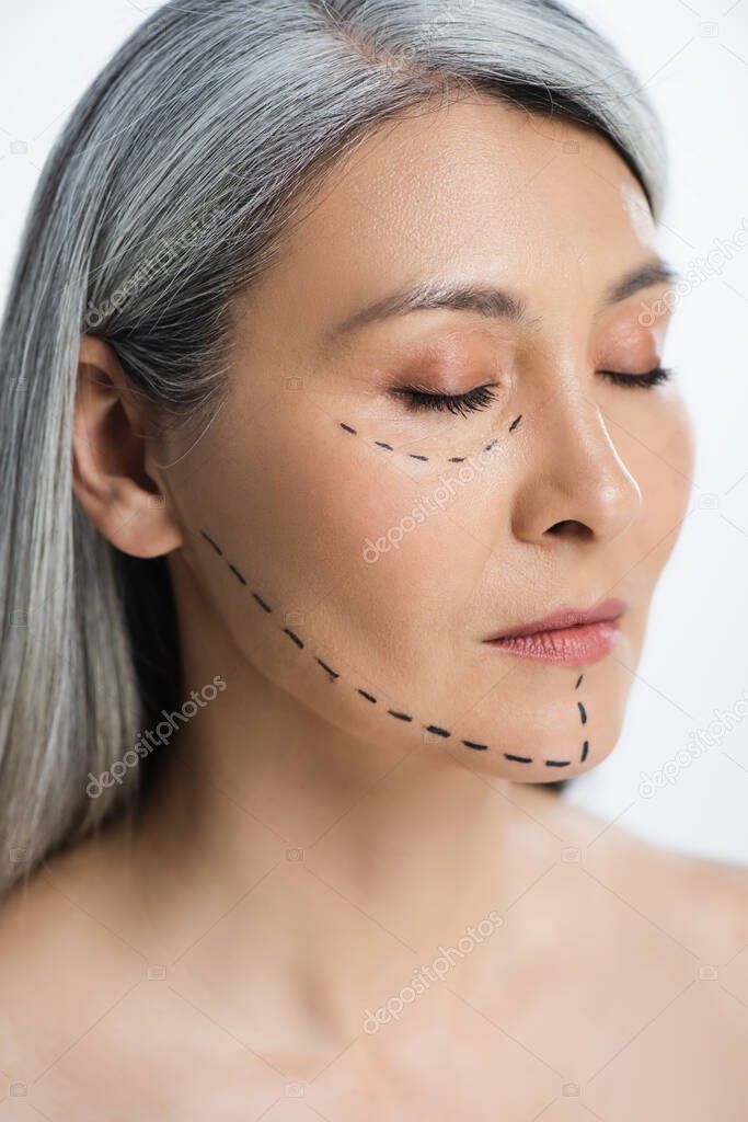asian woman with closed eyes and plastic surgery correction mark on face isolated on grey 