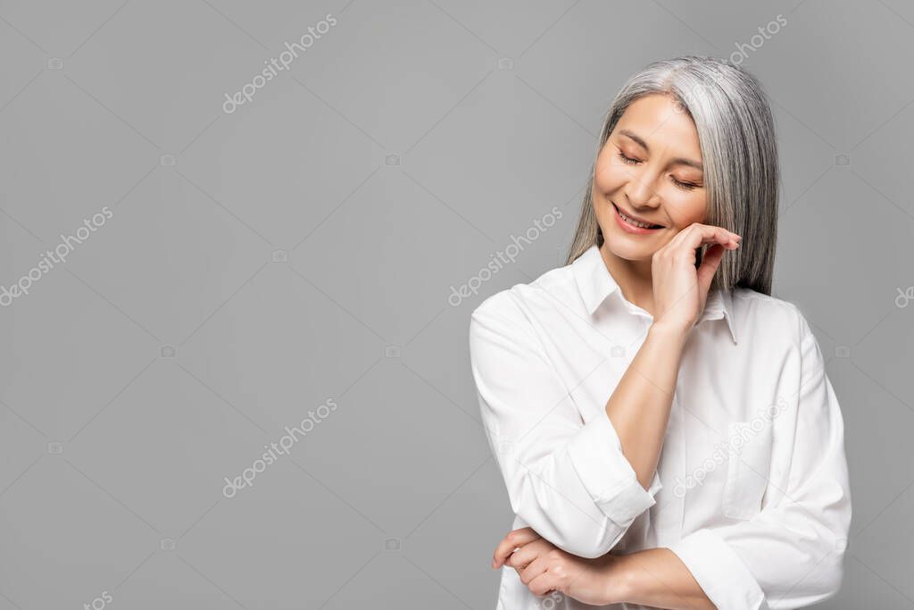beautiful happy asian woman with grey hair isolated on grey