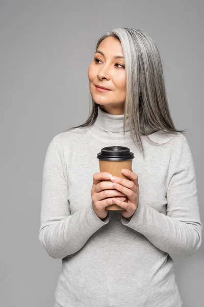 灰色の髪をしたアジア系女性がコーヒーを持ってグレーで隔離され — ストック写真