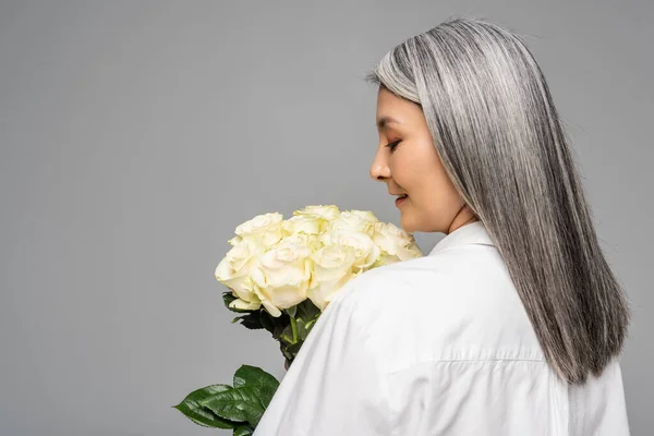 快乐的亚洲女人 白发苍苍 手里拿着一束白色的玫瑰 与灰色隔离 — 图库照片