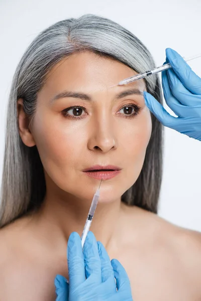 迷人的裸体亚洲女人和医生 戴着乳胶手套 拿着注射器 注射器上有灰色的美感 — 图库照片