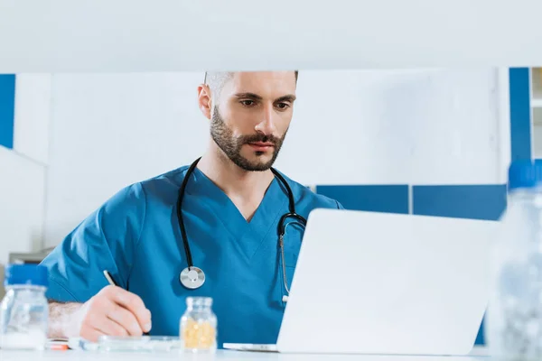 Selective Focus Young Doctor Writing While Looking Laptop — Stock Photo, Image