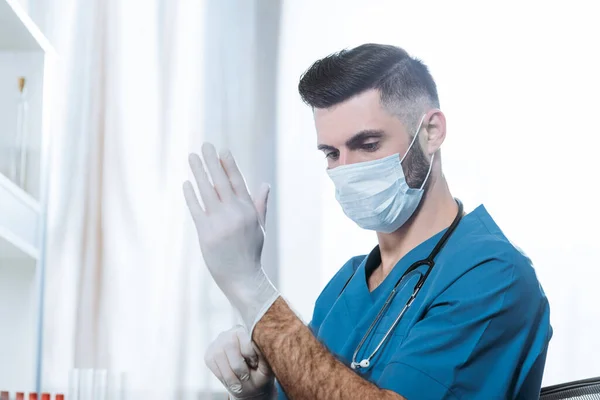 Jovem Médico Máscara Médica Colocando Luvas Látex Protetoras — Fotografia de Stock