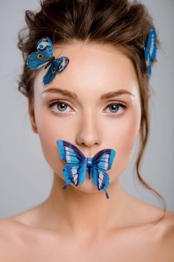 beautiful young woman with decorative butterflies on face isolated on grey  clipart
