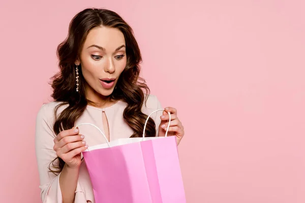Surpresa Jovem Mulher Olhando Para Saco Compras Isolado Rosa — Fotografia de Stock