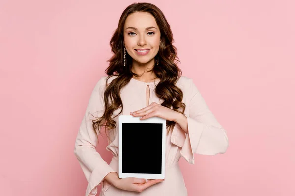 一个快乐的年轻女人拿着空白屏幕的数码平板电脑 用粉色隔开 — 图库照片