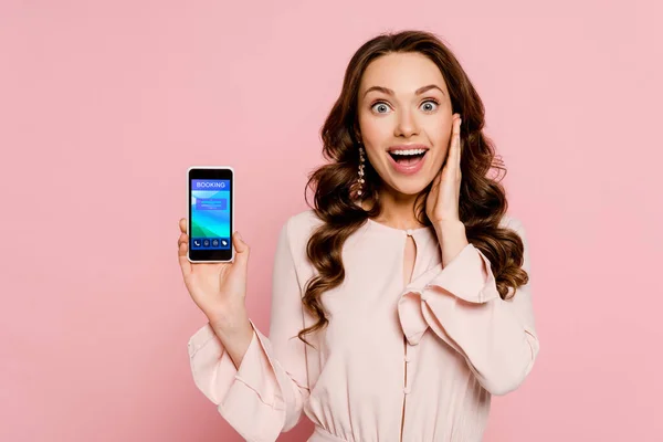 Podekscytowana Dziewczyna Gospodarstwa Smartfon Rezerwacji Ekranie Patrząc Aparat Odizolowany Różowy — Zdjęcie stockowe