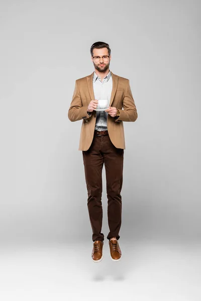 Guapo Hombre Negocios Levitando Sosteniendo Taza Café Gris — Foto de Stock