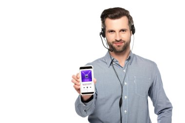 KYIV, UKRAINE - 23 Mart 2020: beyaz ekranda müzik uygulaması ile akıllı telefon kullanan yakışıklı operatör  
