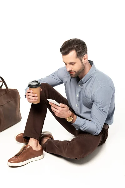 Sakallı Adamı Beyaz Çantanın Yanında Otururken Akıllı Telefon Kullanıyor — Stok fotoğraf