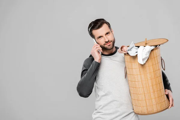 Homem Bonito Segurando Cesta Lavanderia Falando Smartphone Isolado Cinza — Fotografia de Stock