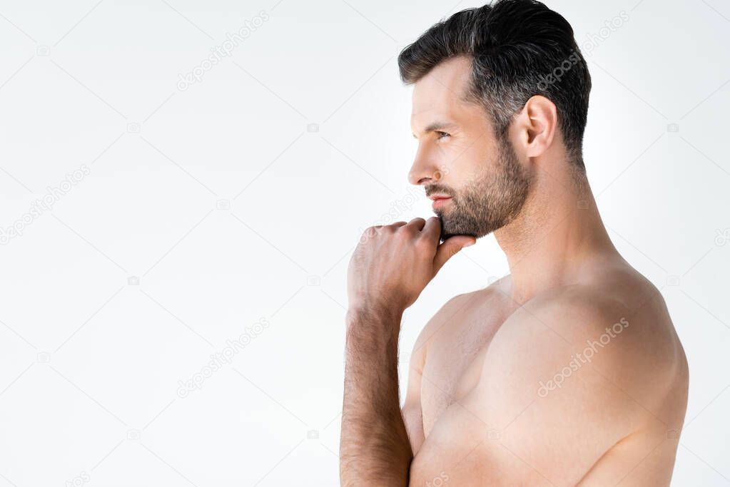 side view of shirtless man thinking and touching face isolated on white 