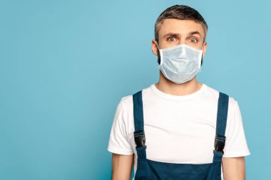 Mavi arka planda tıbbi maskeli temizleyici