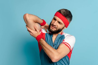 Şık sporcu mavi arka plandaki pazılara bakıyor.