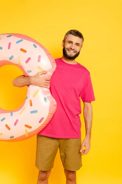 幸せひげを生やした男でピンクTシャツとともに泳ぐリング上の黄色 — ストック写真