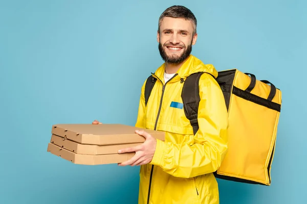 Sırt Çantalı Sarı Üniformalı Gülümseyen Teslimatçı Mavi Arka Planda Pizza — Stok fotoğraf