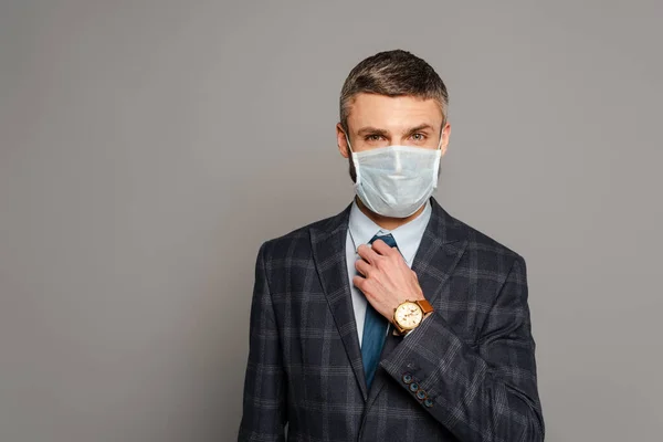 Handsome Businessman Medical Mask Adjusting Tie Grey Background — Stock Photo, Image