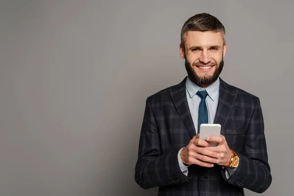 Homem Negócios Barbudo Bonito Feliz Terno Usando Smartphone Fundo Cinza — Fotografia de Stock