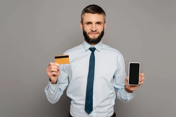 Przystojny Brodaty Biznesmen Posiadający Kartę Kredytową Smartfon Czystym Ekranem Szarym — Zdjęcie stockowe