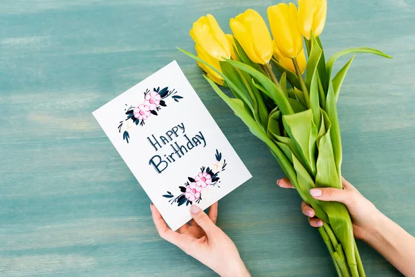 Przycięty Widok Kobiety Trzymającej Kartkę Życzeniami Urodzinowymi Żółte Tulipany Niebieskiej — Zdjęcie stockowe