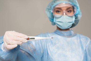 Güvenli Google 'daki doktorun seçici odak noktası termometreyi gri renkte izole ediyor