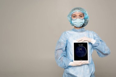 KYIV, UKRAINE - 1 Nisan 2020: Tıbbi maskeli doktor ve iPhone ekranlı dijital tablet tutan lateks eldivenli doktor