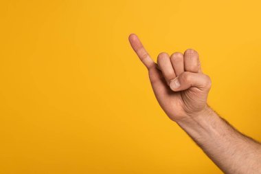 Cropped view of man showing letter in deaf and dumb language isolated on yellow 