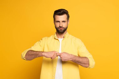 Man looking at camera while showing word friend in deaf and dumb language on yellow background