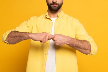 Cropped view of man showing word friend in deaf and dumb language on yellow background