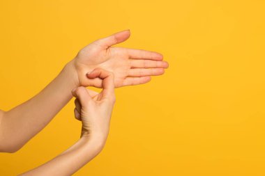 Cropped view of girl using deaf and dumb language isolated on yellow 