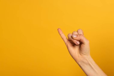 Sarı üzerine izole edilmiş işaret dilinden mektup gösteren kadın görüntüsü 