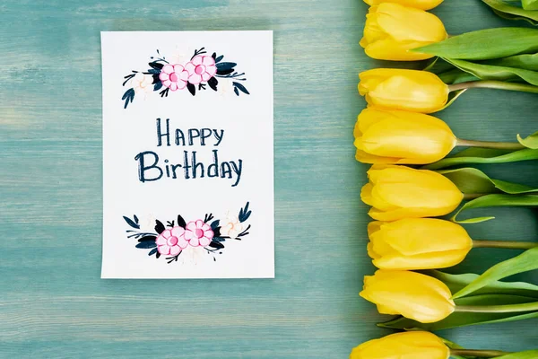 Widok Góry Żółte Tulipany Pobliżu Kartki Życzeniami Urodzinowymi Napisem Happy — Zdjęcie stockowe