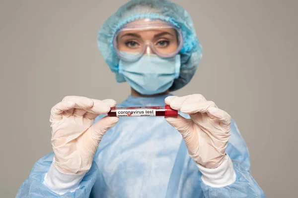 灰色で単離されたコロナウイルスレタリングの血液サンプルと医師保持試験管の選択的焦点 — ストック写真