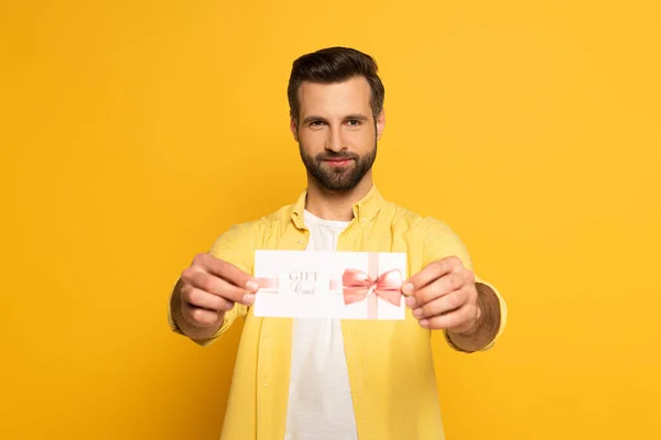 Selective Focus Handsome Man Holding Gift Card Looking Camera Yellow — Stock Photo, Image