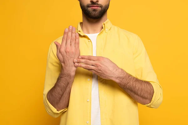 从黄色背景的手语看男人的手势 — 图库照片