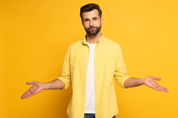 Hezký Muž Ukazuje Pokrčení Rameny Gesto Žlutém Pozadí — Stock fotografie