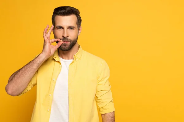 Hombre Guapo Usando Lenguaje Señas Mirando Cámara Sobre Fondo Amarillo —  Fotos de Stock