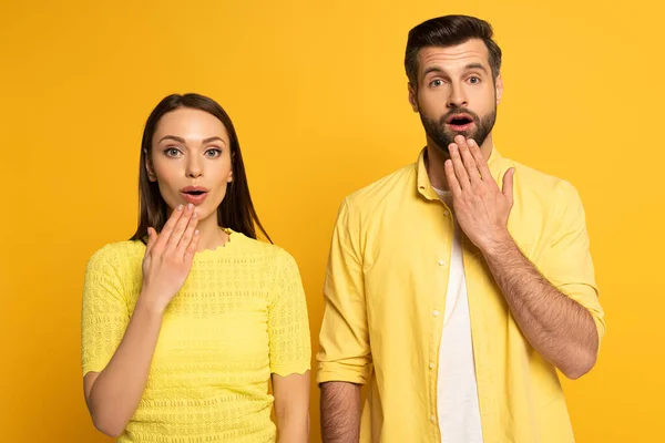 Jovem Casal Chocado Olhando Para Câmera Fundo Amarelo — Fotografia de Stock