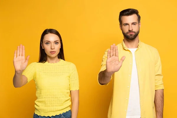 Junges Paar Zeigt Stopp Geste Vor Kamera Auf Gelbem Hintergrund — Stockfoto