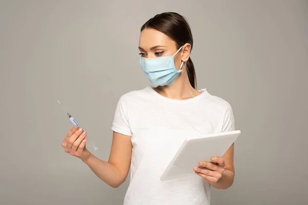 女の子で医療マスク保持注射器とデジタルタブレット絶縁オングレー — ストック写真